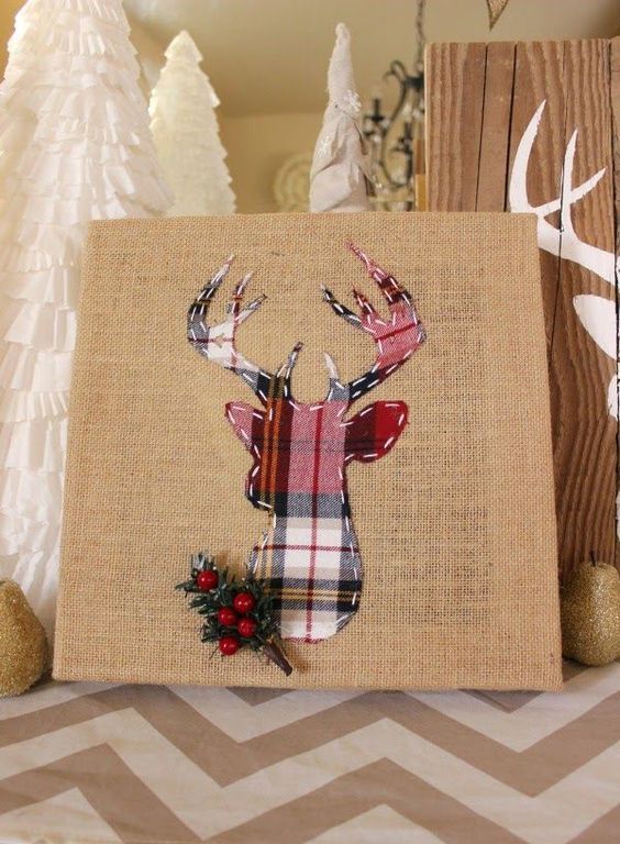 a burlap sign with a plaid deer, faux greenery and berries looks rustic and creative