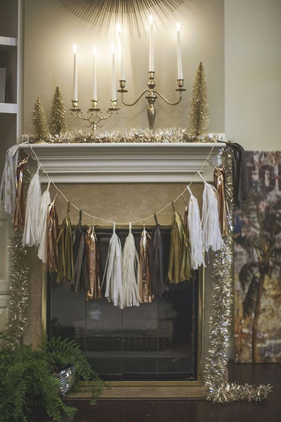 a metallic tassel garland over the fireplace and tinsel garlands