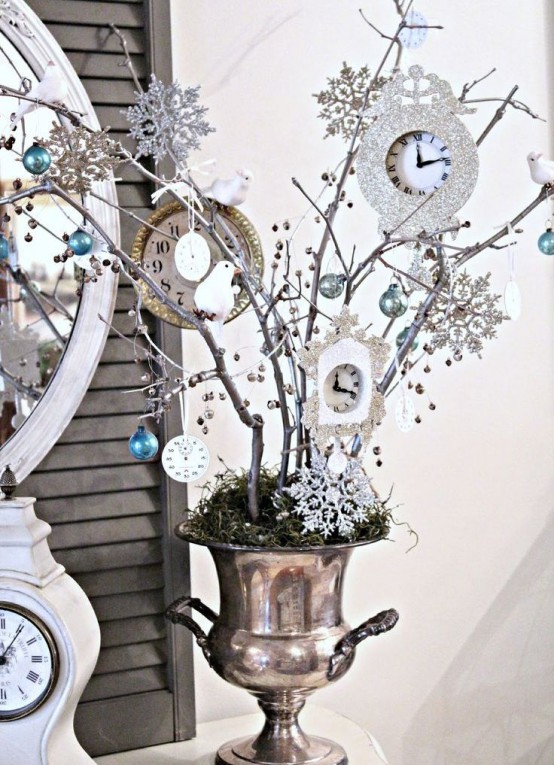 a vintage vase with moss and branches decorated with snowflakes, ornaments and clocks