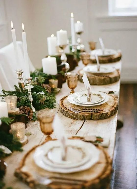 a lush garland with pinecones and candles, wood slice chargers and amber glasses for an elegant rustic tablescape