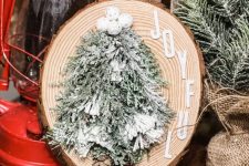 a rustic Christmas sign with flocked evergreens, pinecones, snowballs and letters looks very nice and festive-like