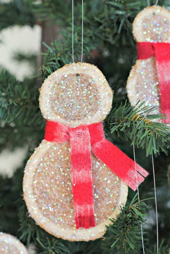 cute and super simple glitter wood slice snowman Christmas ornaments with red scarves look very chic and very cool