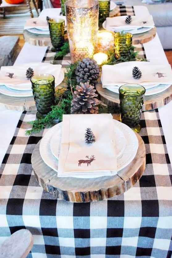 large pinecones, green glasses, greenery and mercury glass candle holders, wood slices as chargers
