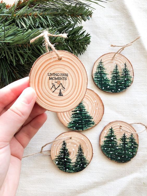 pretty tree slice ornaments with painted Christmas trees and snow are absolutely adorable