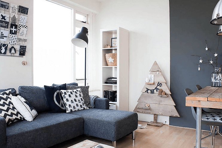 A large sectional sofa is in the center, and lots of reclaimed wood add interest to the interior. IKEA Kallax unit serves as a minimalist display