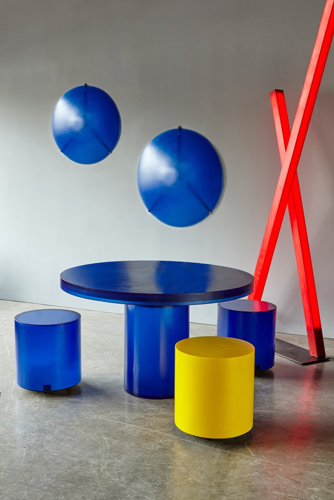The round Chief stool has a cylindrical form, in blue, yellow or red, and the table has a circular surface and a single leg and is made from blue resin The round Chief stool has a cylindrical form, in blue, yellow or red, and the table has a circular surface and a single leg and is made from blue resin