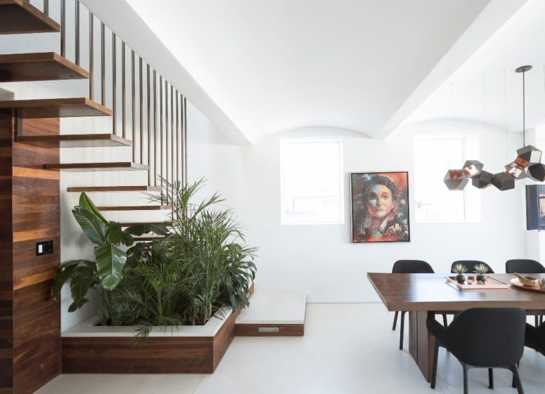 The dining zone is done with a mid century modern dining set, eye catchy geometric lamps and there's much greenery potted under the stairs The dining zone is done with a mid-century modern dining set, eye-catchy geometric lamps and there's much greenery potted under the stairs