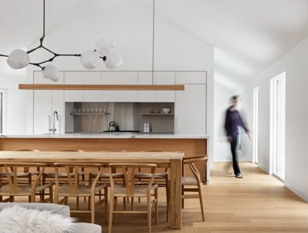 The kitchen features a white cabinets, a marble kitchen island and natural wood, of which the dining set is made too The kitchen features a white cabinets, a marble kitchen island and natural wood, of which the dining set is made too