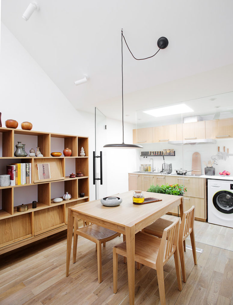 The kitchen is attic, with much light-colored plywood in decor, and there's a cozy dining space next to it