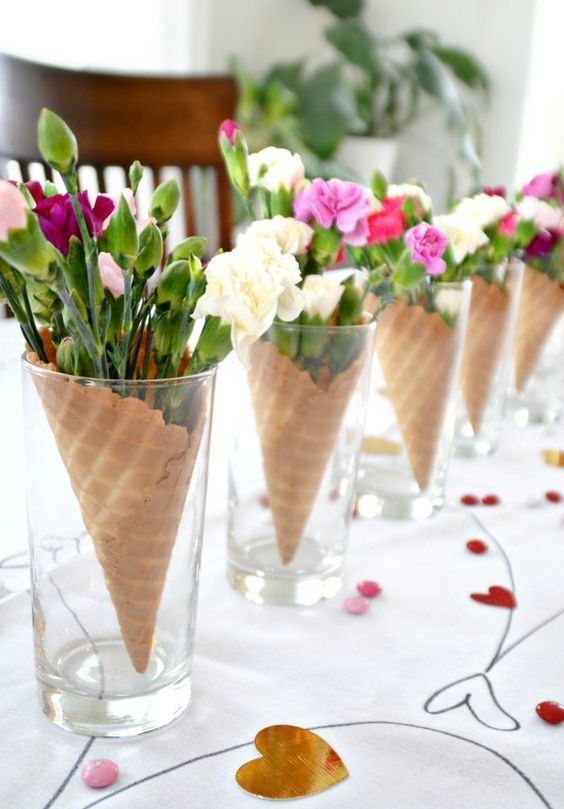 a cool galentine's brunch centerpiece of ice cream cones filled with blooms