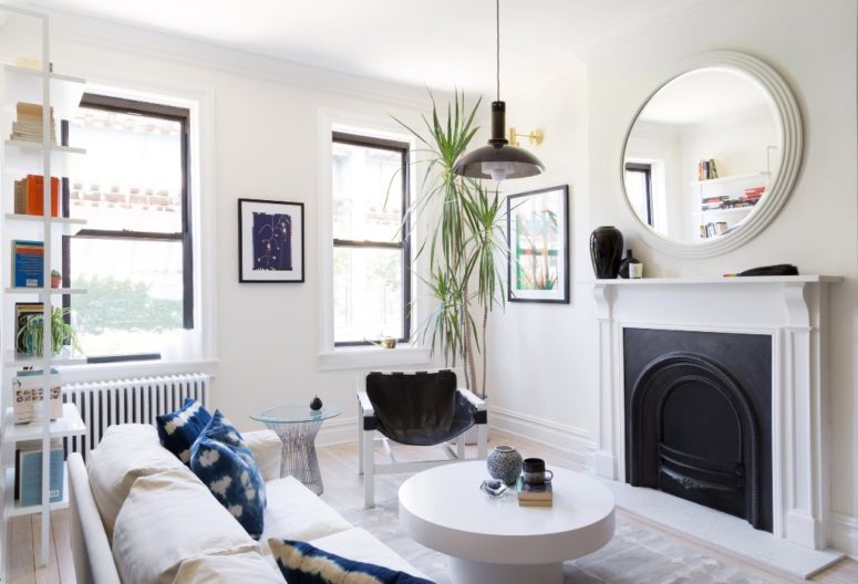 The living room is furnished with comfy modernist furniture, there's a an antique fireplace and a bookshelf in the corner The living room is furnished with comfy modernist furniture, there's a an antique fireplace and a bookshelf in the corner