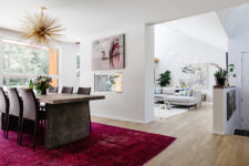 04 The living room is partly divided from the dining room with a fuchsia rug, a bunburst chandelier and a bold artwork