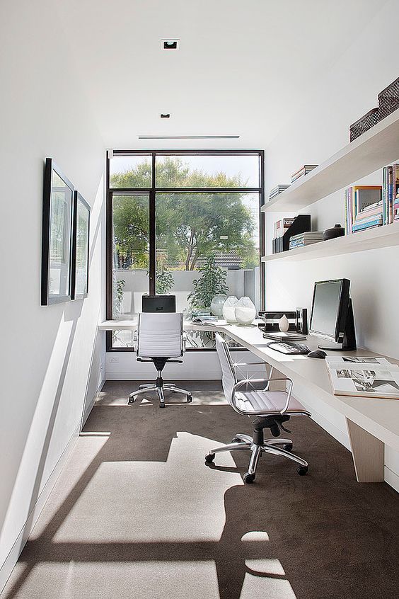 a modern shared home office with a floating desk for two and shelves over it