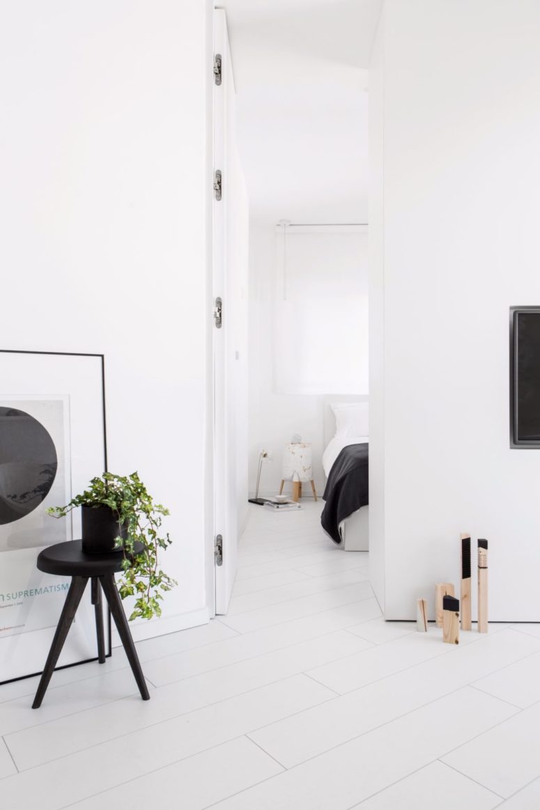 The smart wall between the living room and bedroom features a TV on one side and a wardrobe on the other side