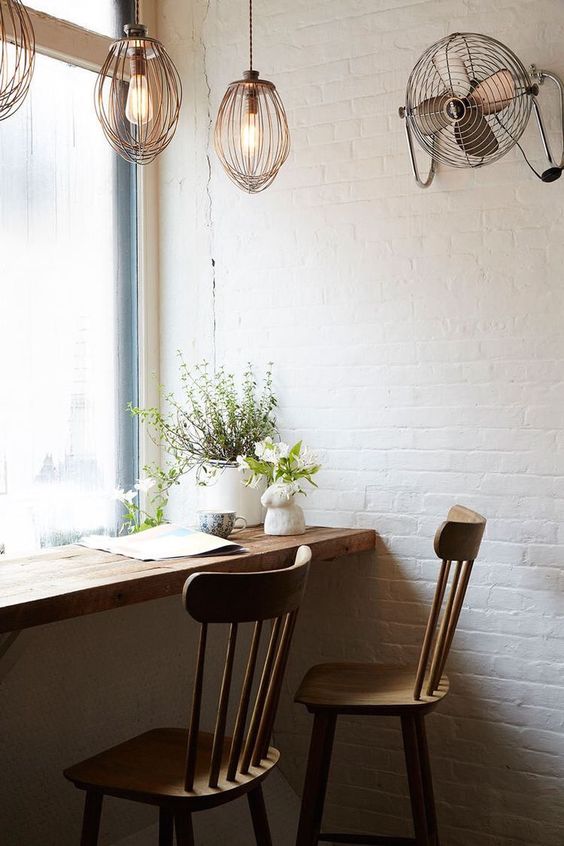 a wooden windowsill and chairs make an industrial space cozier