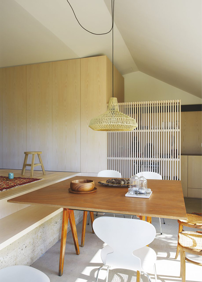 The dining space and the kitchen are divided with a plywood screen