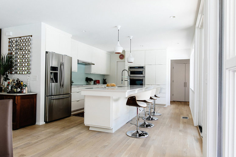 The kitchen with white cabinets and a large kitchen island is only visually separated from the dining room The kitchen with white cabinets and a large kitchen island is only visually separated from the dining room