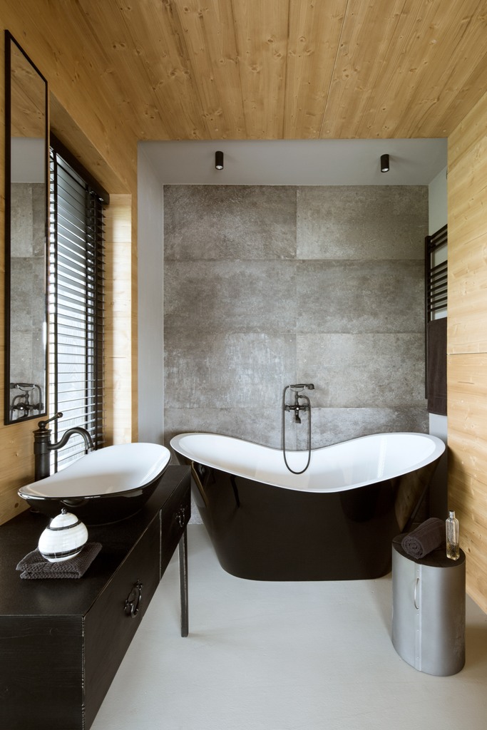 minimalist bathroom with wood and concrete decor The master bathroom is clad with light-colored wood, there's a concrete wall and an elegant black sink and bathtub