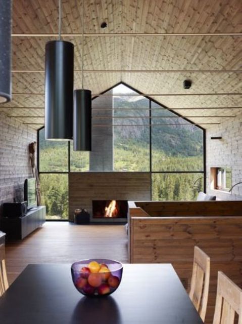 a fully glazed wall with a fireplace makes outside merge with inside