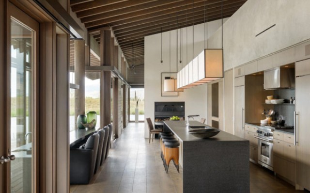 The kitchen is done with beige cabinets, a stone clad kitchen islands and a dining space along the window to enjoy the views The kitchen is done with beige cabinets, a stone clad kitchen islands and a dining space along the window to enjoy the views