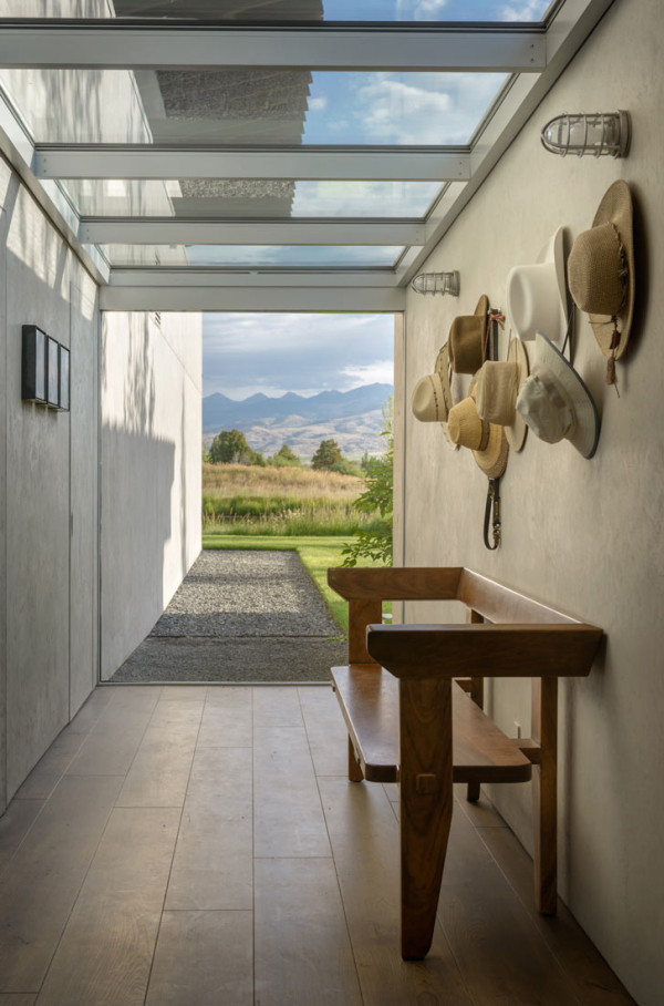 The entryway features a vintage wooden bench and some cowboy hats paying tribute to the ranch nature of this land