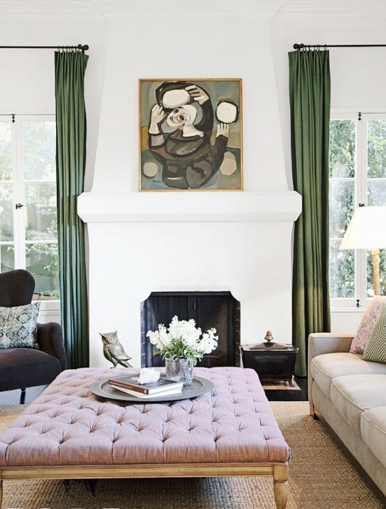 a refined living room with a pink upholstered ottoman that doubles as a coffee table