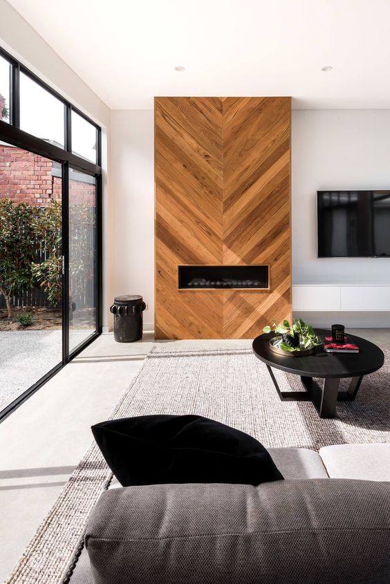a fireplace unit clad with wood in a chevron pattern for a unique touch