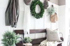 12 a farmhouse entryway with a vintage wooden bench and baskets for storage under it