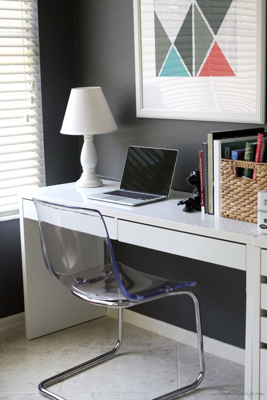a modern workspace done with a Micke desk, an acrylic modern chair and a crate for storage