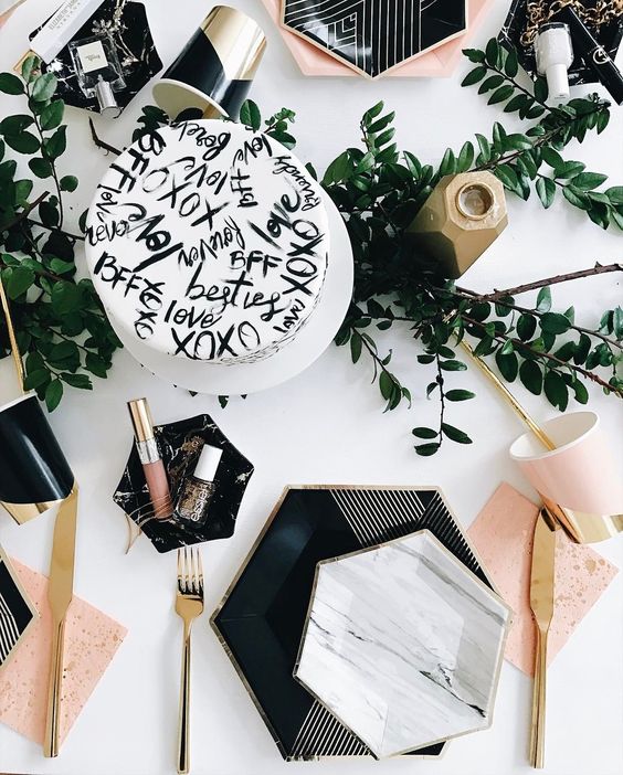 a stylish tablescape with hexagon plates and chargers, touches of marble and geometry