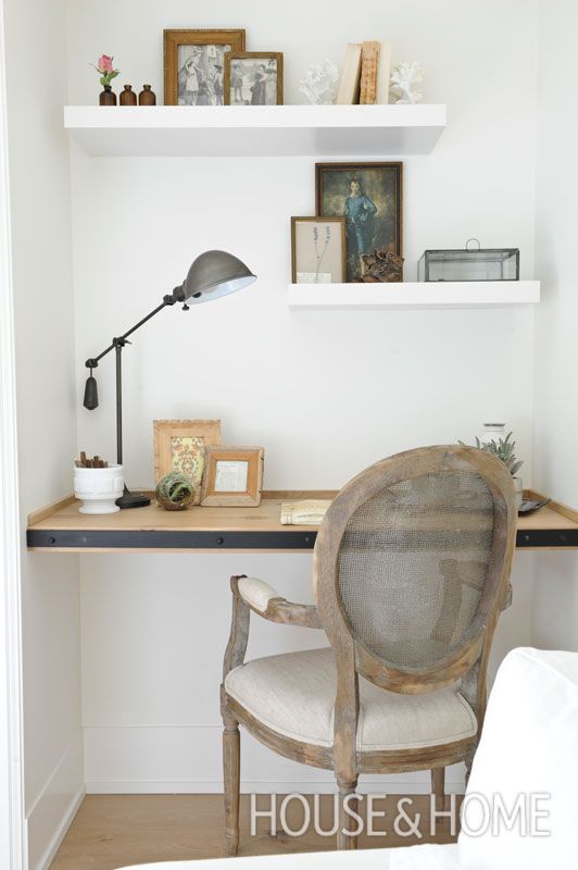 a small home office nook with floating shelves and a desk covered with blackened steel