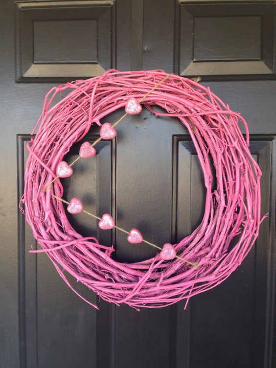 a modern pink grapevine wreath with pink glitter hearts for the front door decor