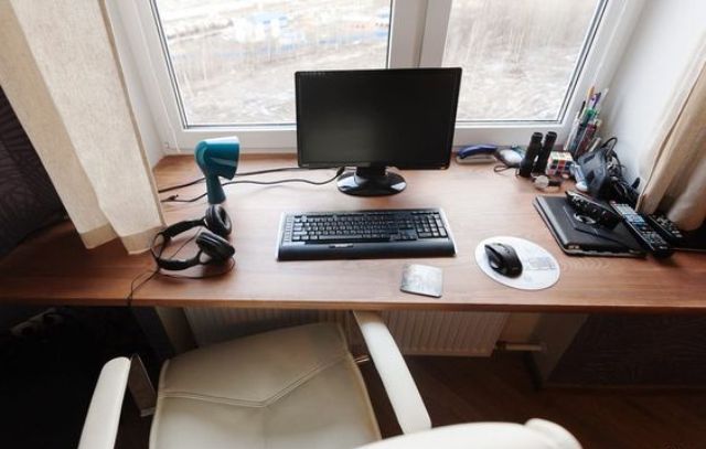 a small working space on the windowsill and a comfy white leather chair