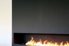 18 a long, horizontal fireplace clad with dark metal looks ultra-minimalist