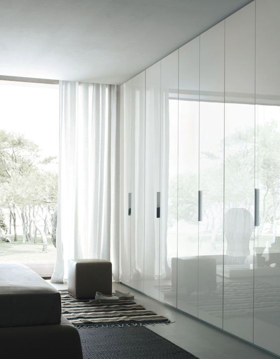 sleek white doors with handles look shiny and reflect natural light making the space look larger