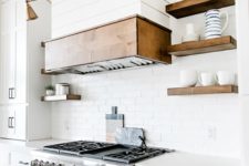 23 a stainless steel cooker and some brass lamps are nicely paired in the kitchen