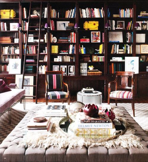 an oversized neutral upholstered ottoman and coffee table in a library