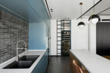 02 The kitchen includes blue cabinet, a large wine cooler and a kitchen island with a breakfast space