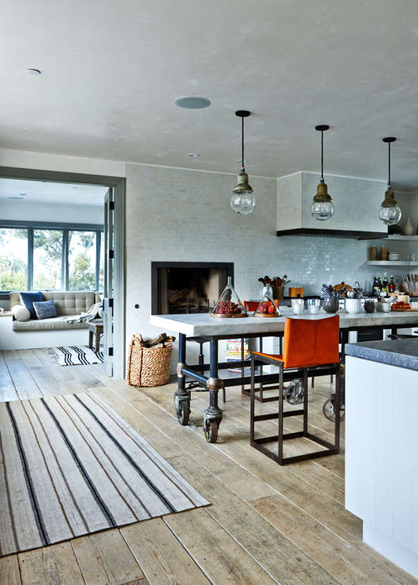 The kitchen is done with whit glossy tiles and unique industrial furniture chairs and a large table on casters that were custom made The kitchen is done with whit glossy tiles and unique industrial furniture - chairs and a large table on casters that were custom-made