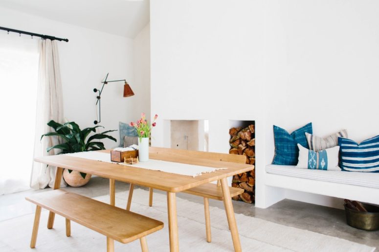 There's a dining space with an amazing built-in bench and firewood storage, a mid-century modenr dining set