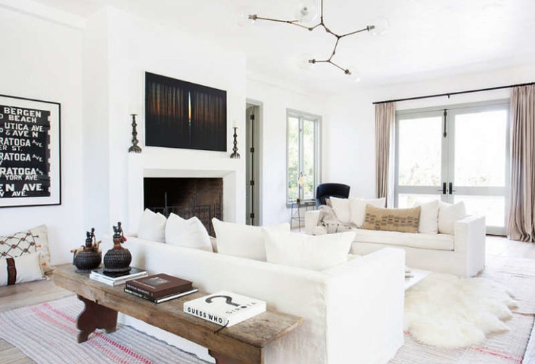 The living room is a gorgeous large space filled with whites and light, a fireplace and some rustic touches that add coziness The living room is a gorgeous large space filled with whites and light, a fireplace and some rustic touches that add coziness