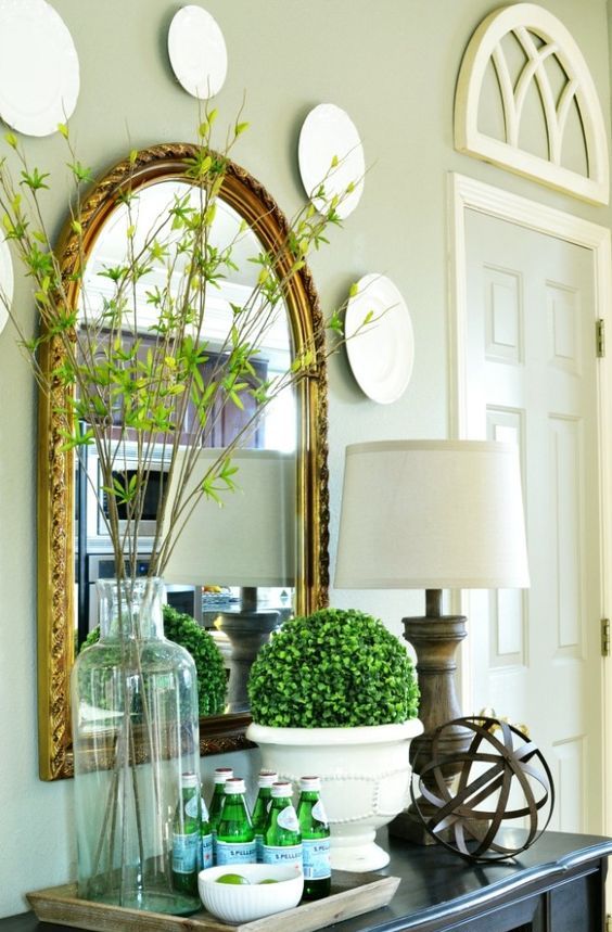 a boxwood topiary in a pot and fresh green branches in a jar for simple spring decor