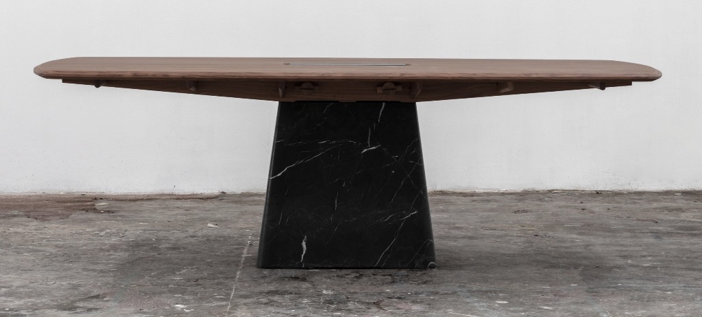 The Dolmen dining table is placed on a black marble base, too and has interesting edges