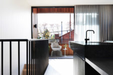 04 The kitchen island is all-black, and it’s extended to a dining table