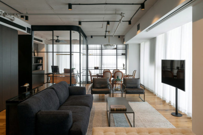 The living room and dining space are united into one but visually separated with a couple of chairs and a side table The living room and dining space are united into one but visually separated with a couple of chairs and a side table