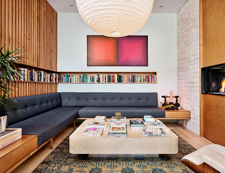 The living room is done with a large corner sofa, a built in bookshelf and is centered around the fireplace The living room is done with a large corner sofa, a built-in bookshelf and is centered around the fireplace