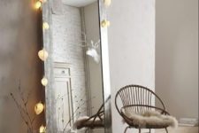 04 an oversized floor mirror with string lights makes the space cooler and inviting
