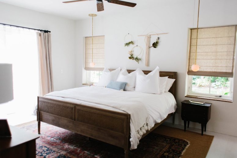 I love the wooden bed and floral hangings over it, vintage rugs and Roman shades bring that tropical and boho feel