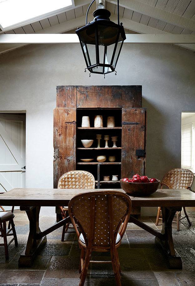 The dining space shows off a fantastic antique weathered cupboard, some woven chairs and a rustic dining table The dining space shows off a fantastic antique weathered cupboard, some woven chairs and a rustic dining table