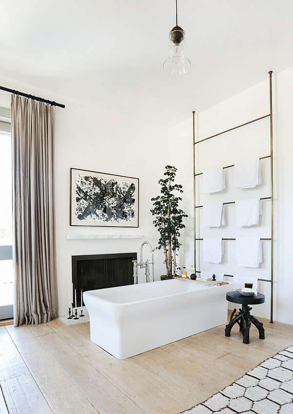 The master bathroom is a gorgeous space with a fireplace, blush curtains, artworks and potted plants The master bathroom is a gorgeous space with a fireplace, blush curtains, artworks and potted plants